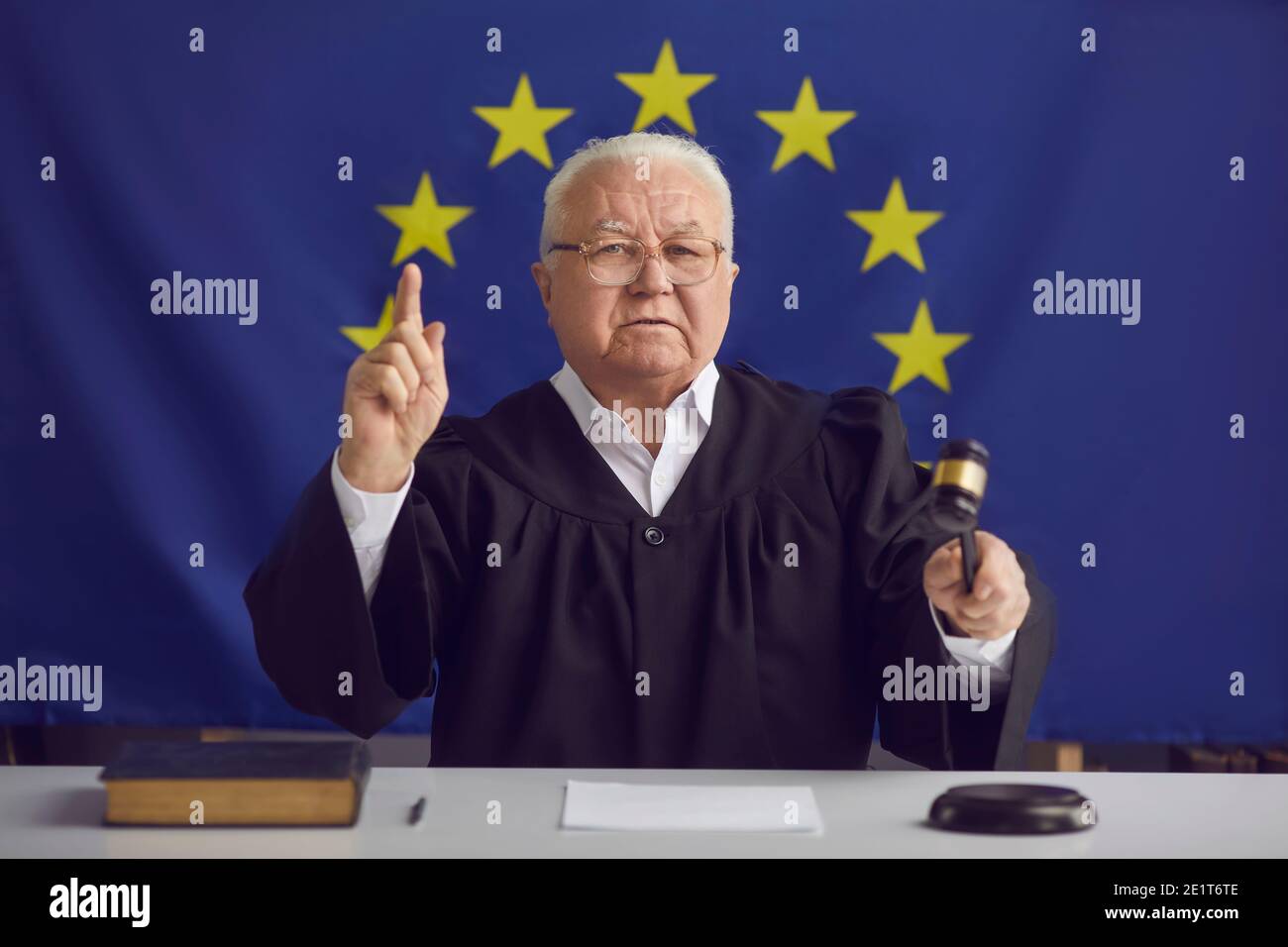Serious judge of European Court of Justice holding gavel and pronouncing sentence Stock Photo