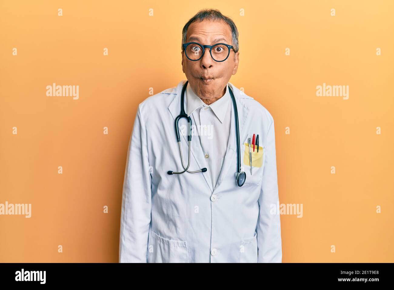 Middle age indian man wearing doctor coat and stethoscope making fish face  with lips, crazy and comical gesture. funny expression Stock Photo - Alamy