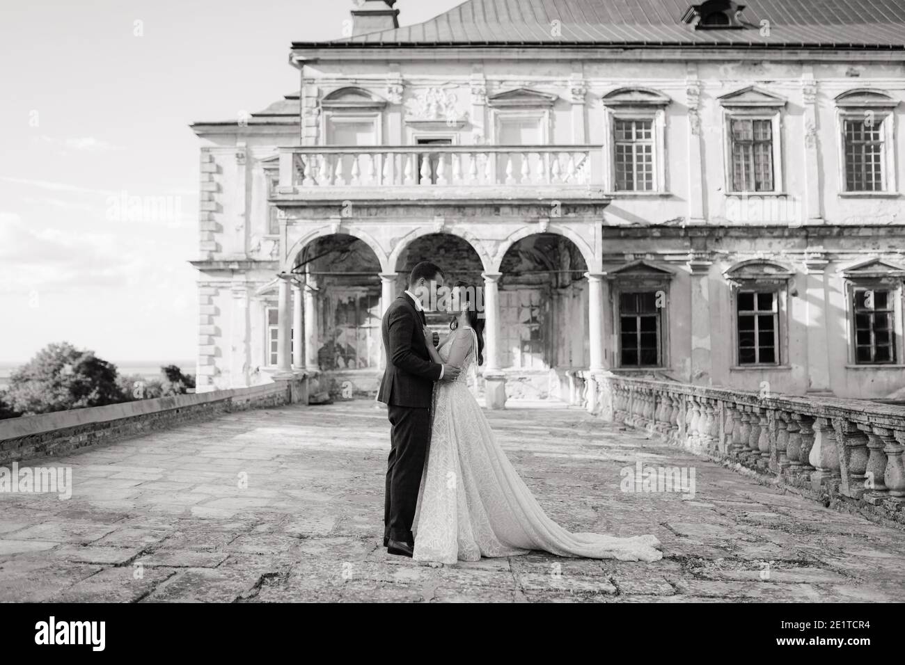 Bride and groom standing in front of each other and embracing. Black and white  Stock Photo