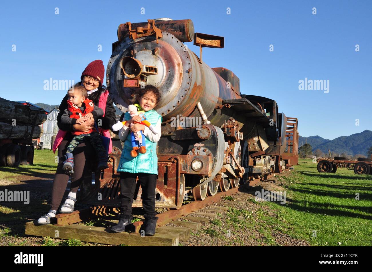 Family standing in front of an old vintage steam powered train Stock Photo