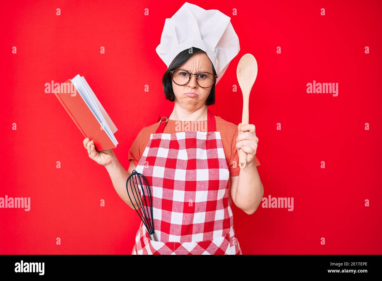 Brunette woman with down syndrome wearing professional baker apron ...
