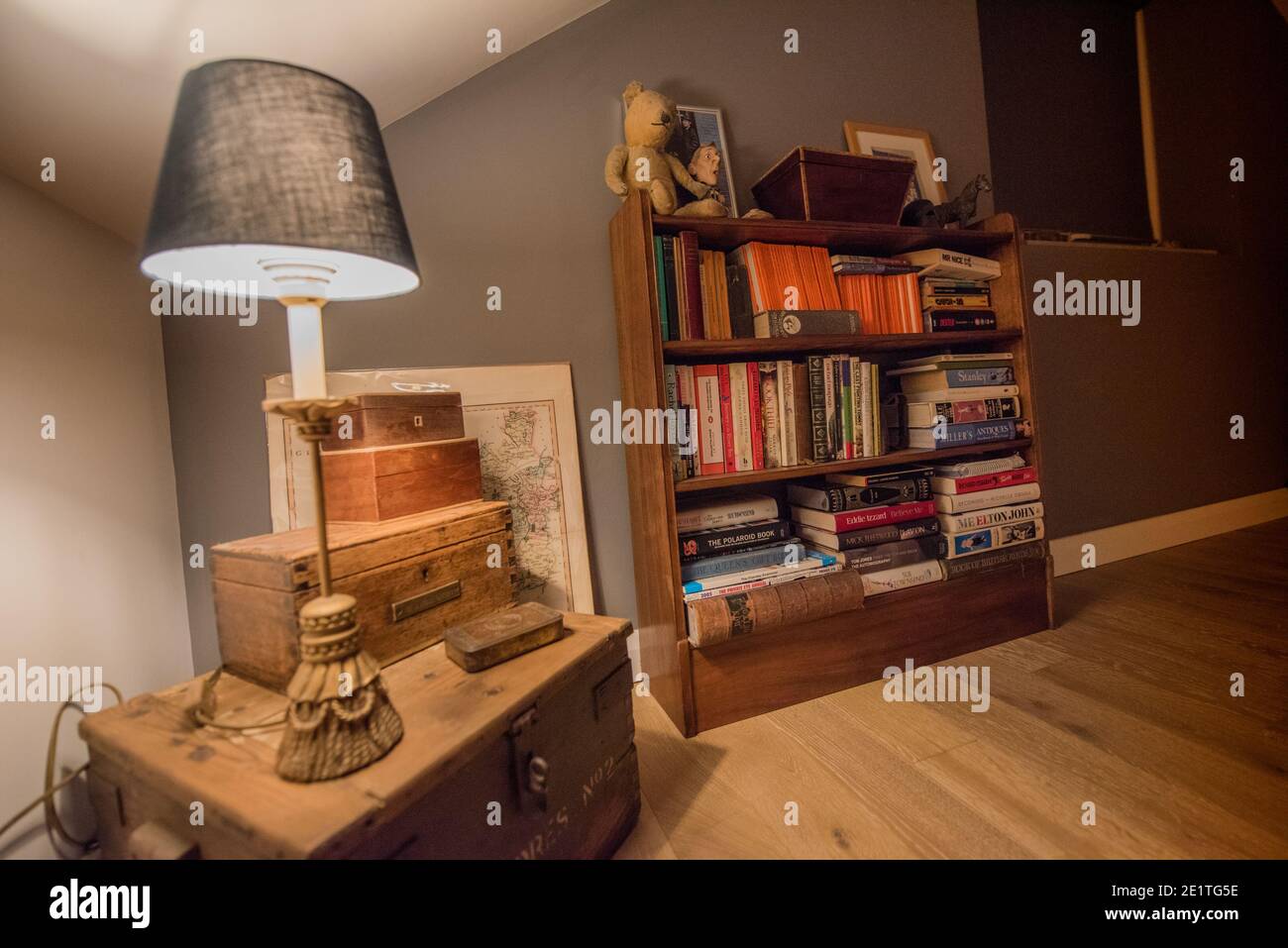 Section of a loft conversion showing a fancy lamp on an old World War Two  tool box for an artillery gun, a teak book case, wooden floor Stock Photo -  Alamy