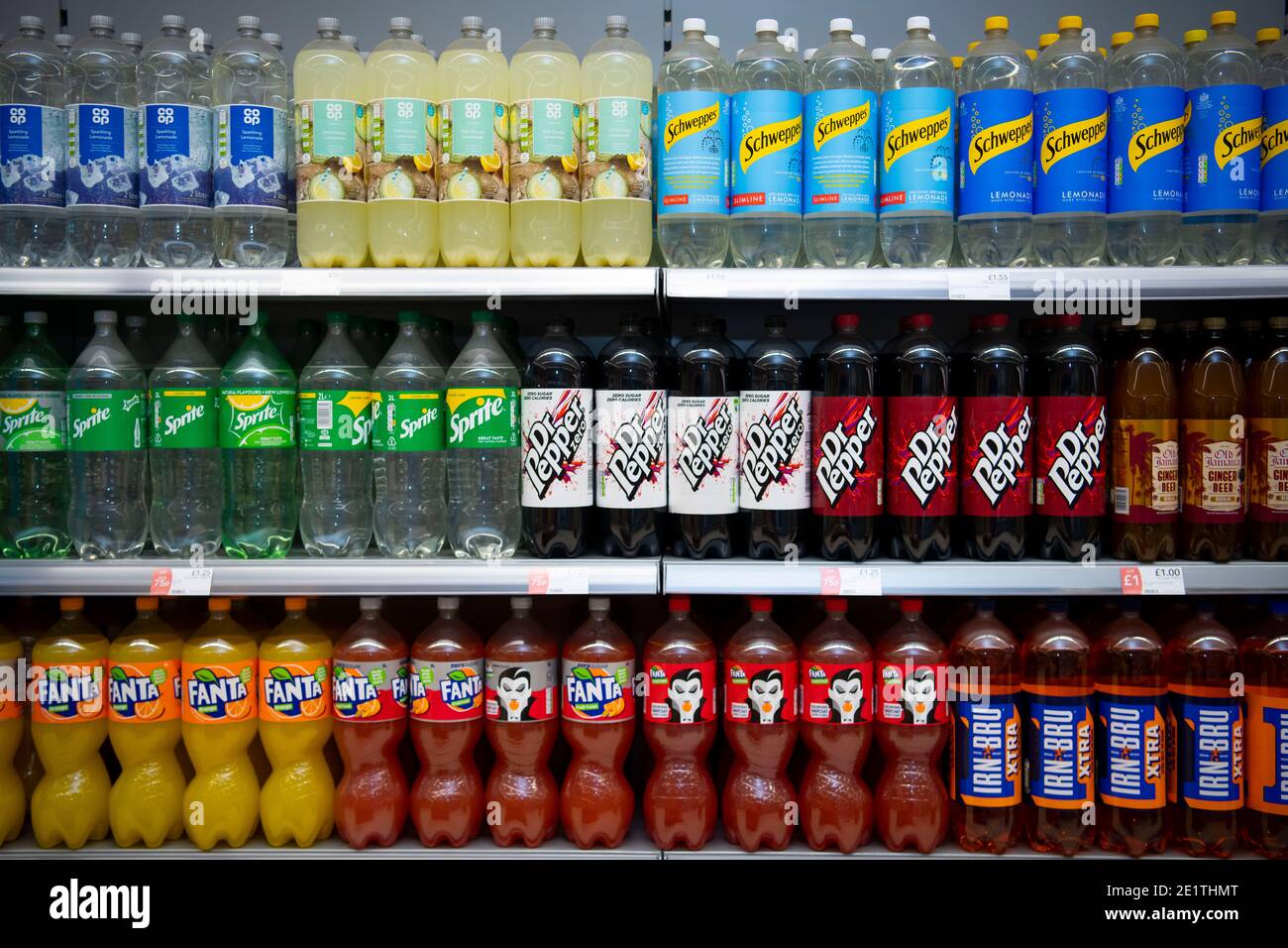 Bottles of 2 litre fizzy drinks on sale on a supermarket shelf in