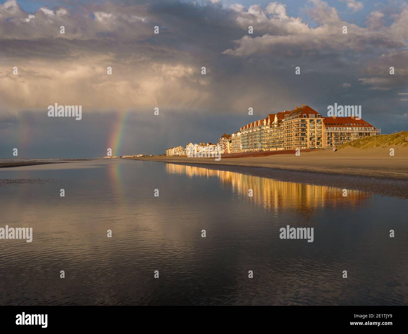 Colorful rainbow at the beach under dramatic sky Stock Photo