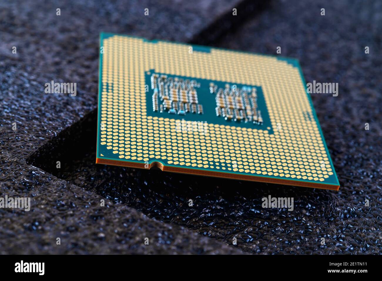 Pc micro CPU with gold plated contacts on a textured dark background. Modern central processing unit close-up. Desktop computer hardware macro. Stock Photo