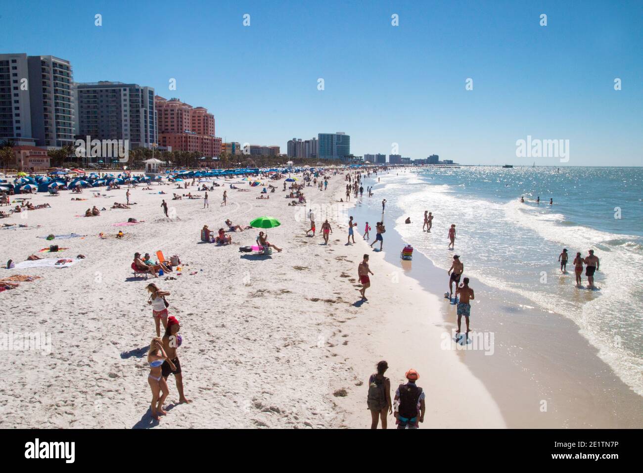 Crowded beach by sunbathing and walking people on holidays, exotic sandy beach vacation, tourists Florida Clearwater beach view Stock Photo