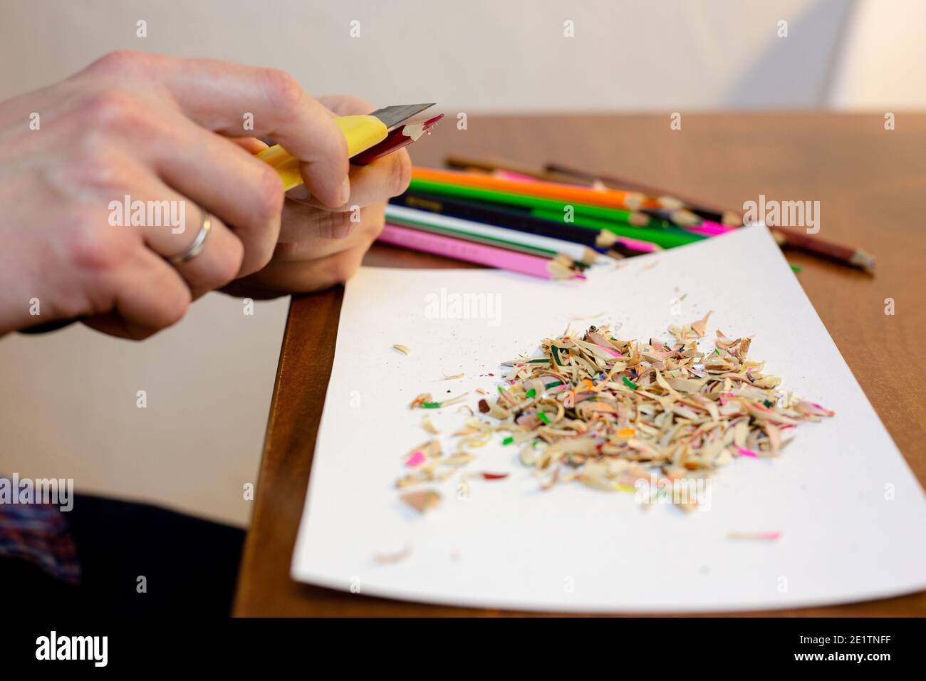 A man sharpens a pencil with a stationery knife Stock Photo Alamy