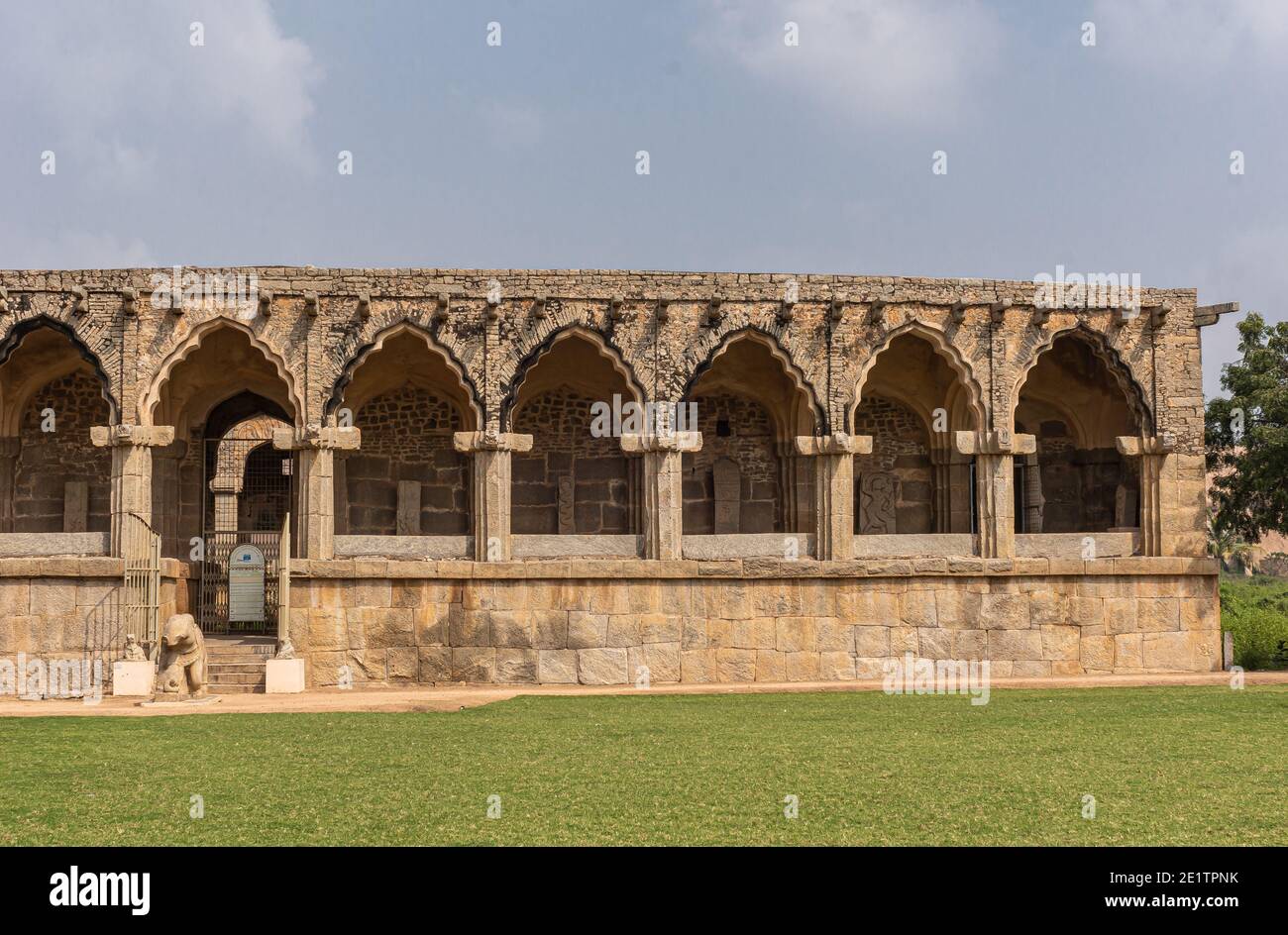 Hampi, Karnataka, India - November 5, 2013: Zanana Enclosure. Low historic brown-stone building where archaeological artifacts are displayed under blu Stock Photo