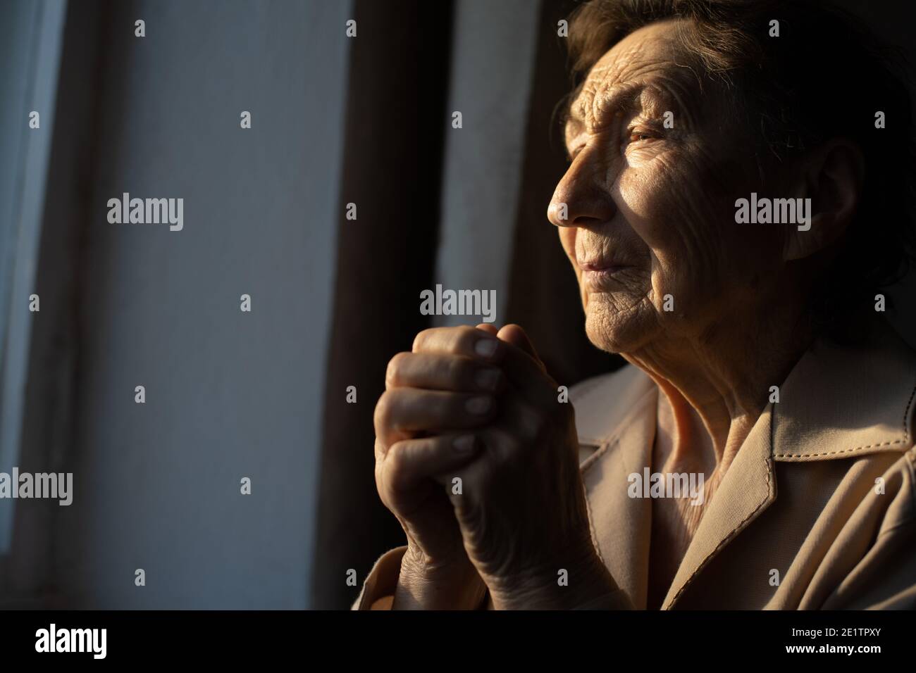 Close up portrait of an old woman praying Stock Photo