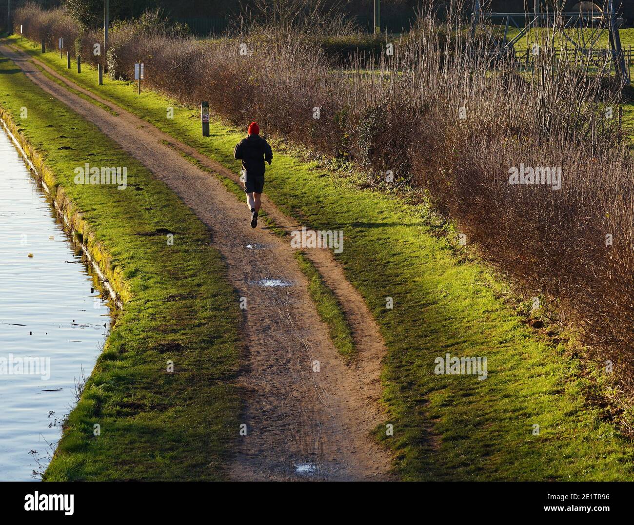 Lone man jogging down a towpath Stock Photo Alamy