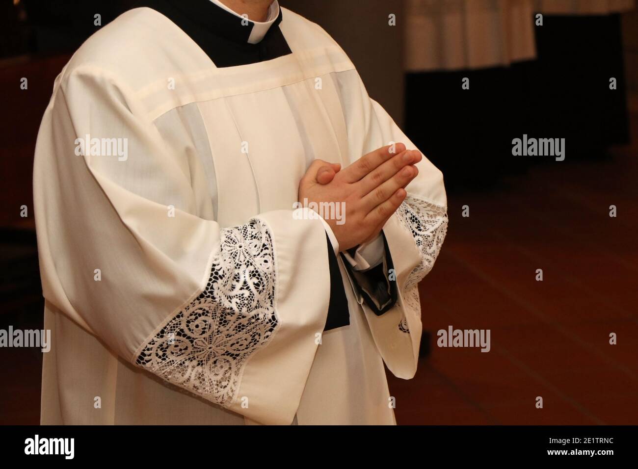 Young priest with his hands folded in prayer Stock Photo - Alamy
