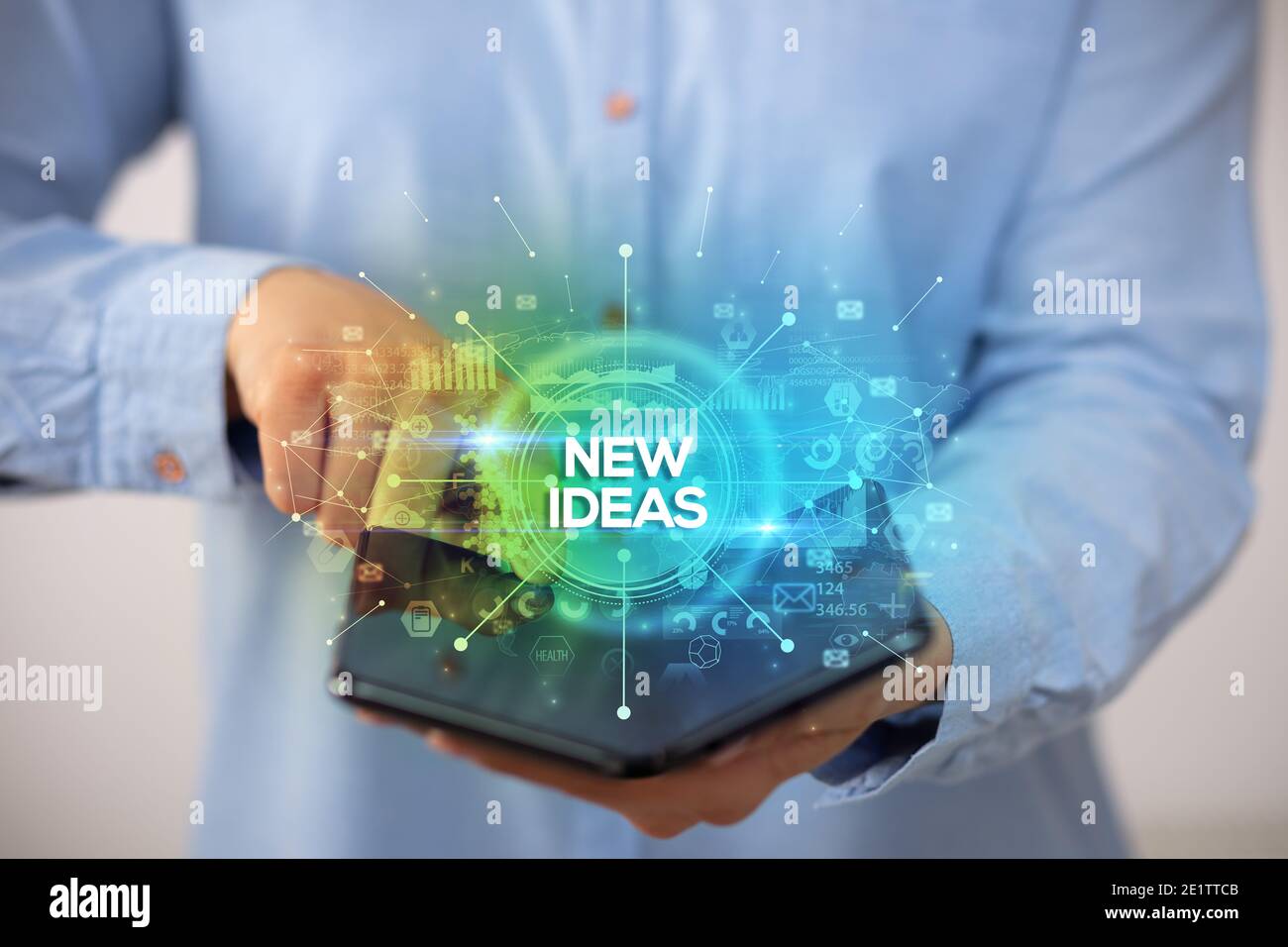 Businessman holding a foldable smartphone with NEW IDEAS inscription, new business concept Stock Photo