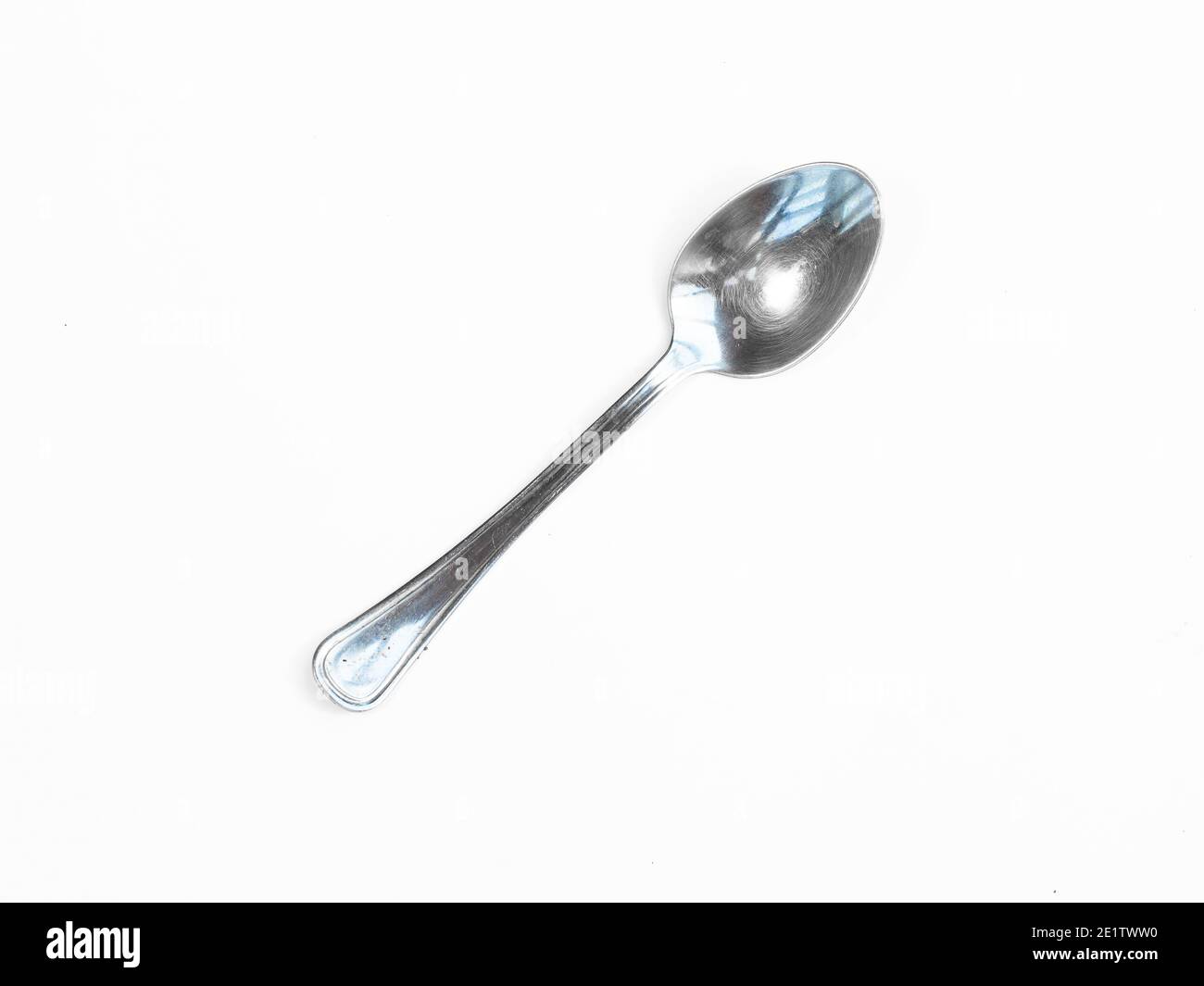 Silver spoon stands vertically with shadow isolated on white.silver spoon isolated on white