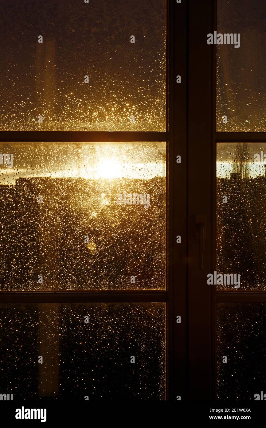 raindrops on a window pane at sunset Stock Photo