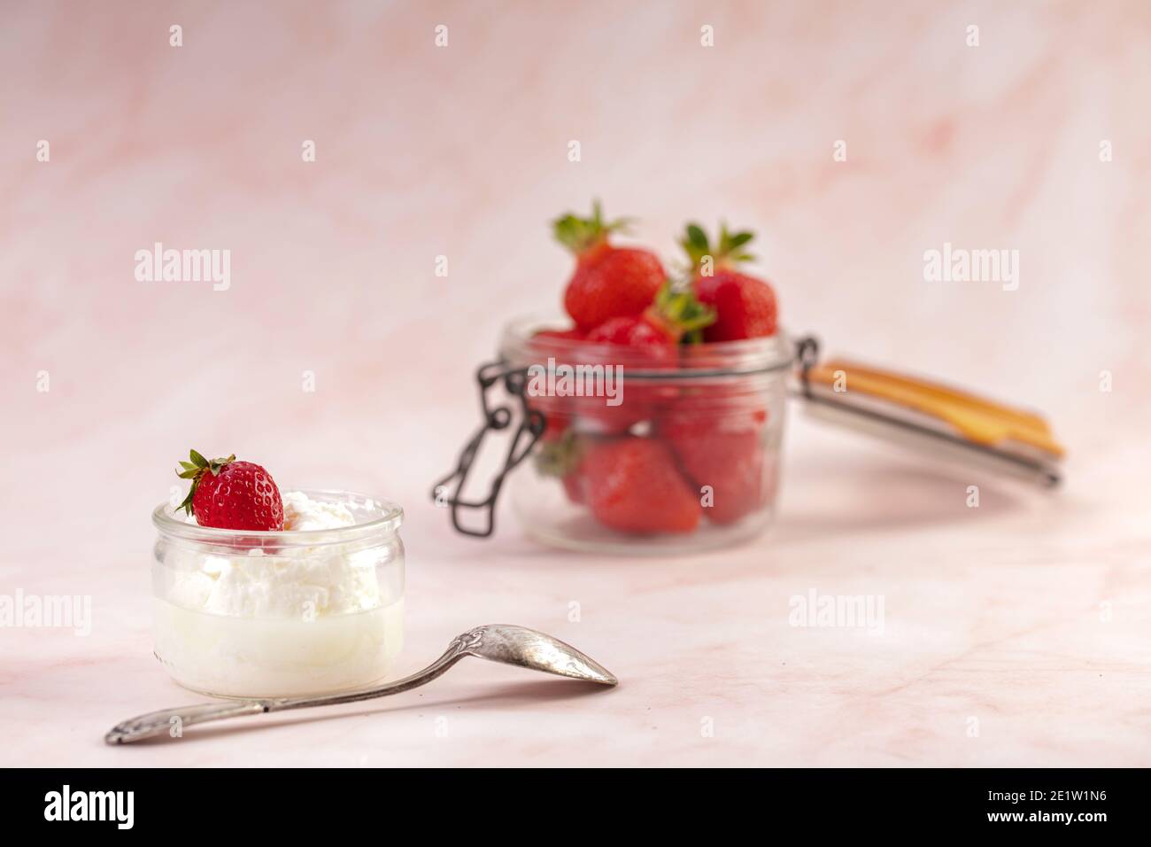 Strawberries in a glass jar on a pink background Stock Photo - Alamy