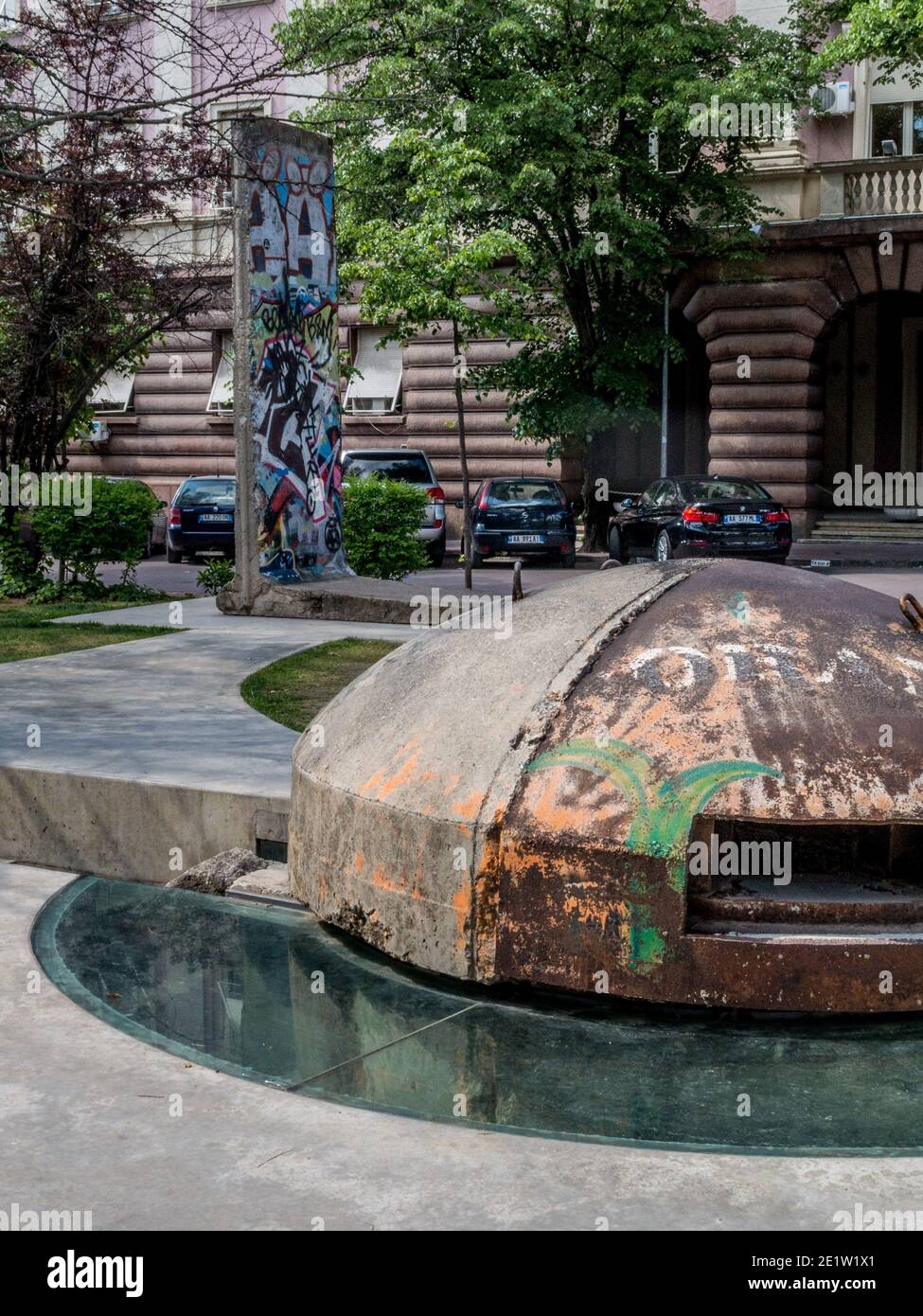 Bunker and piece of the Berlin Wall in downtown park, Tirana, Albania. Communist-era bunkers were built by dictator Enver Hoxha during the Cold War Stock Photo