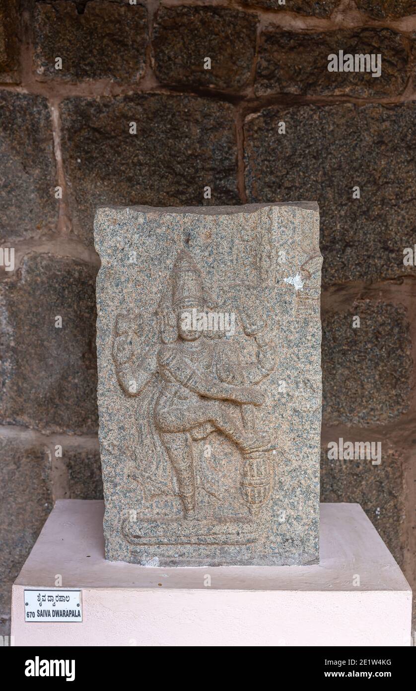 Hampi, Karnataka, India - November 5, 2013: Zanana Enclosure. Closeup of gray-stone Shiva Dwarapalaka statue on white pedestal at archeological items Stock Photo