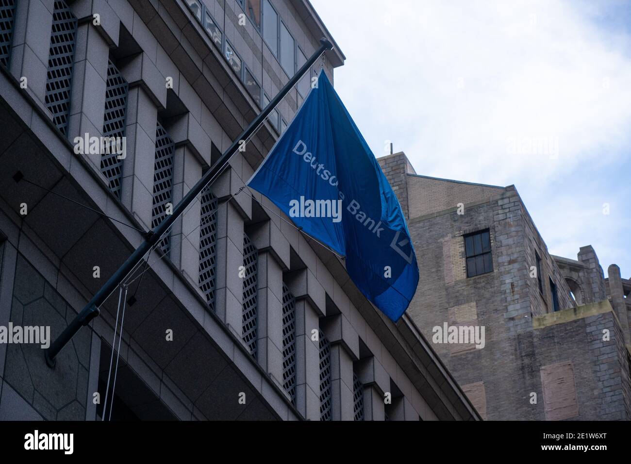 NEW YORK, NY – JANUARY 09: Deutsche Bank flag hangs from Deutsche Bank AG New York Headquarters on Wall Street on January 9, 2021 in New York City. Deutsche Bank AG has agreed to pay more than $130 million to settle criminal and civil charges resulting the Federal government's investigation into bribery of foreign officials and manipulated the market for precious-metals futures through a trading tactic known as spoofing.  Deutsche Bank AG is still under investigation by New York State for its dealing with Trump Organization. Stock Photo