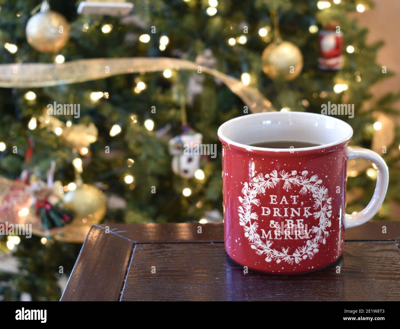 https://c8.alamy.com/comp/2E1W8T3/holiday-picture-with-a-festive-coffee-mug-and-a-christmas-tree-in-the-background-2E1W8T3.jpg