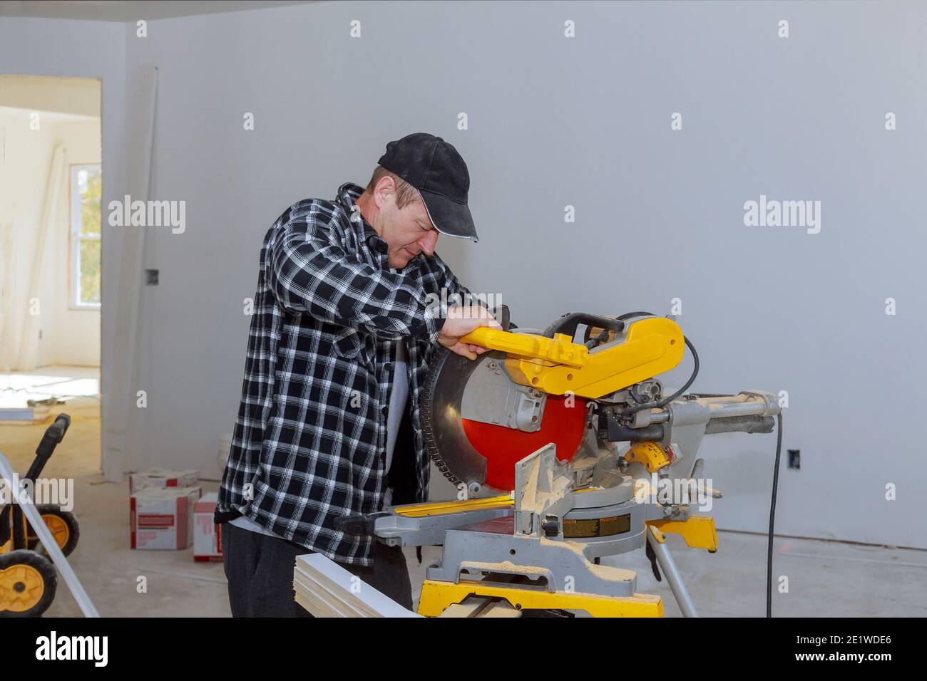 Construction home cutting wooden trim molding on with circular saw