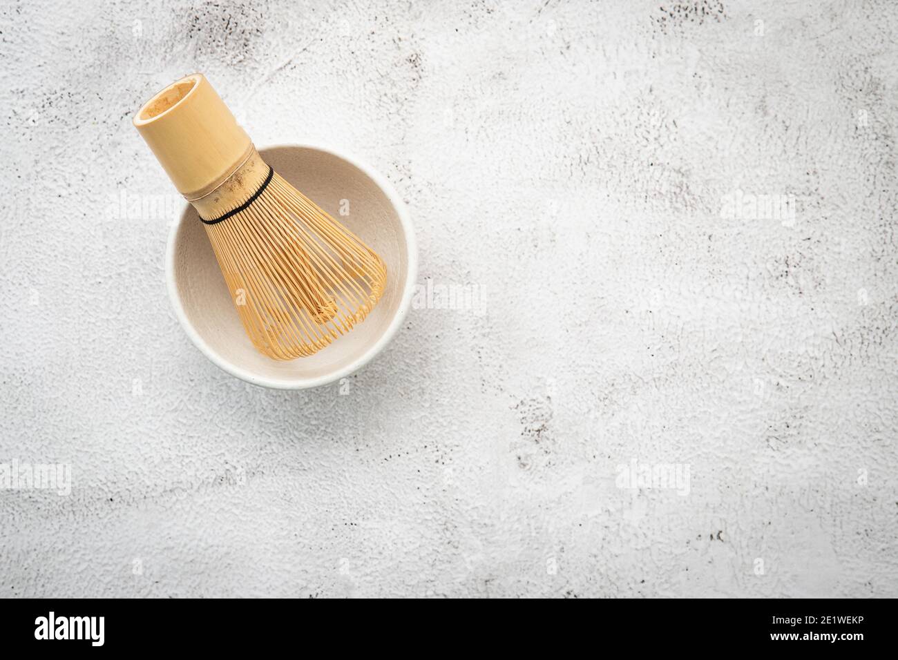 Matcha set bamboo matcha whisk and chashaku tea scoop,matcha ceramic bowl set up on white concrete background. Stock Photo