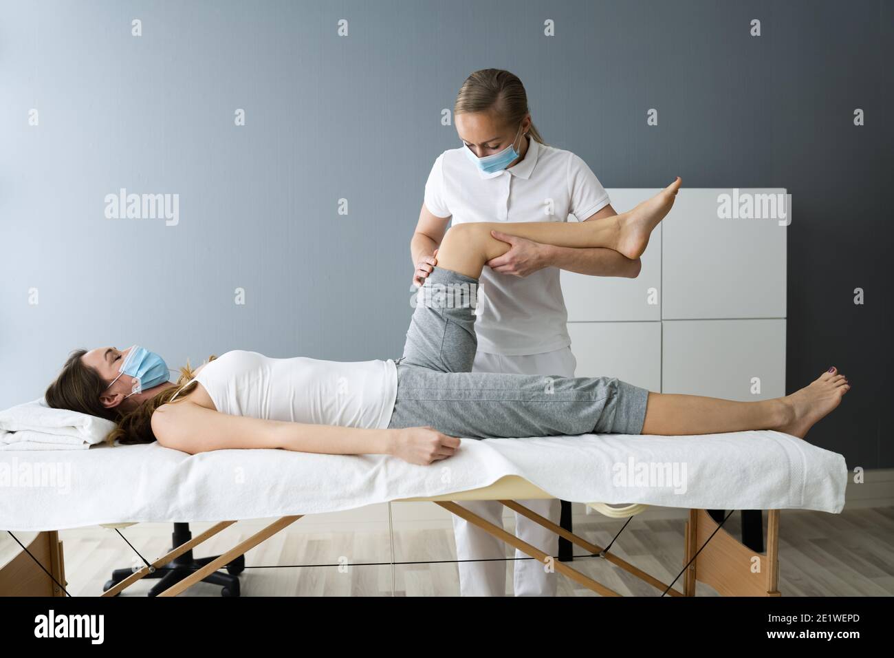 Knee Injury Rehab Massage And Physiotherapy In Face Mask Stock Photo