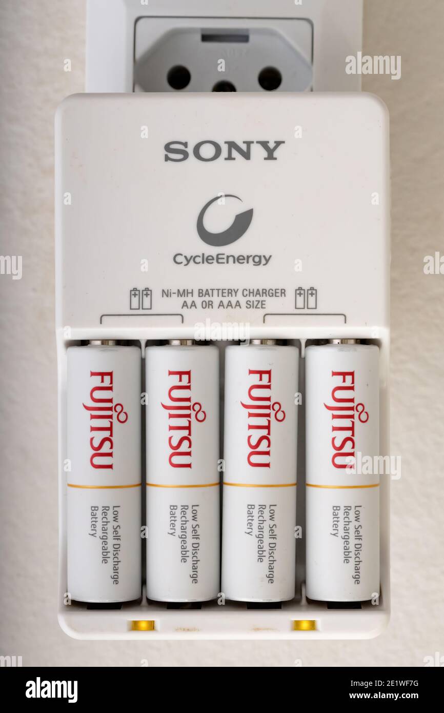 Cassilandia, Mato Grosso do Sul, Brazil - 01 08 2020: Sony charger in the socket charging four fujitsu AA batteries Stock Photo
