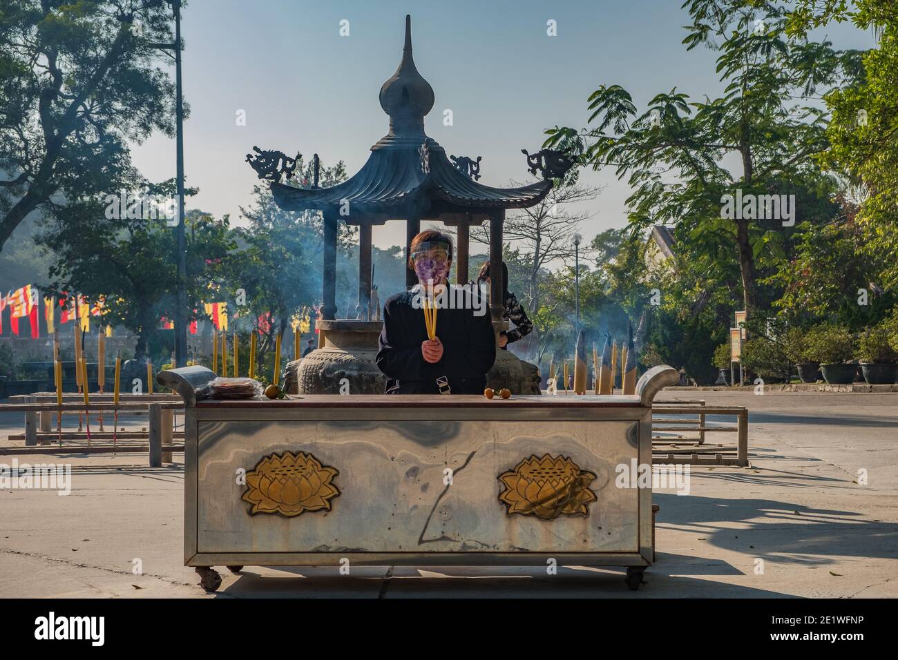 A person prays in front of Po Lin Monastery in Ngong Ping village on Lantau Island, Hong Kong Stock Photo