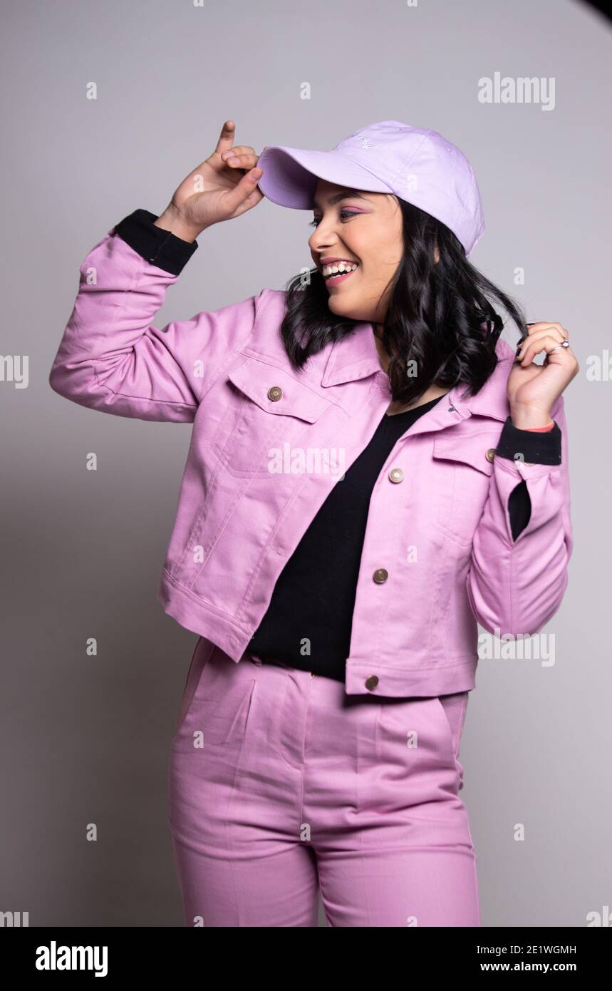 Portrait of Beautiful smiling woman in pink outfit with pink cap looking at her right side Stock Photo