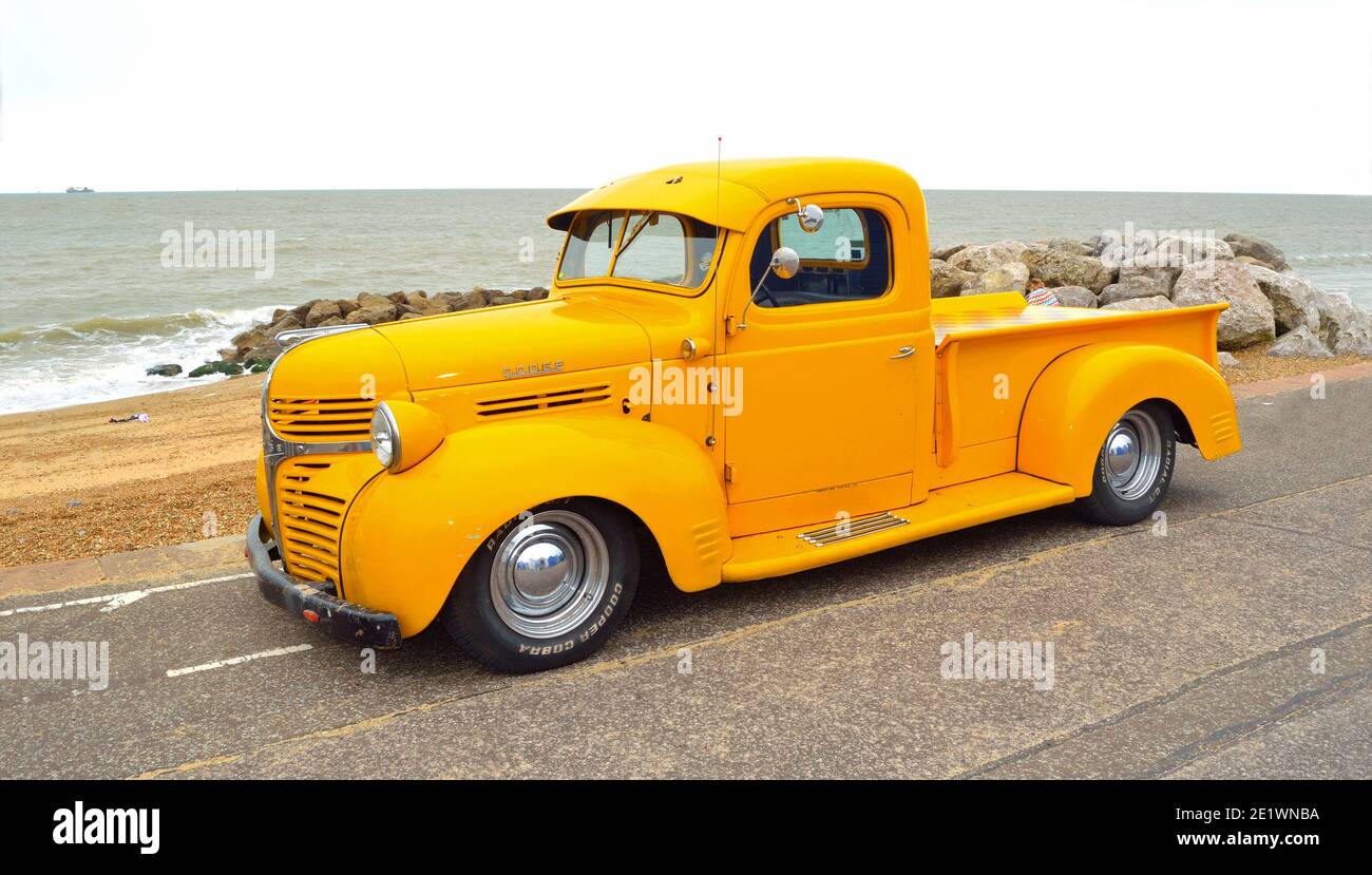 Classic Yellow Dodge  pickup truck on seafront promenade with sea in background Stock Photo