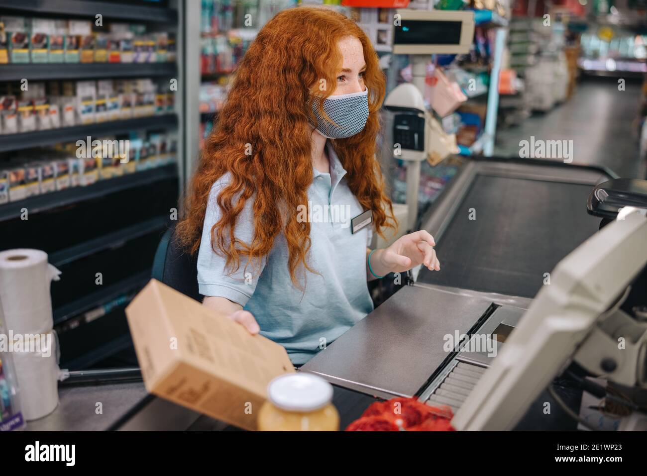 Female Grocery Store Worker Working At Checkout Counter Woman Cashier