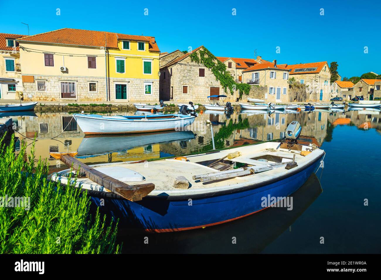Excellent travel and vacation destination. Fishing and touristic village with stone houses reflected on the sea. Moored fishing boats in Vrboska villa Stock Photo