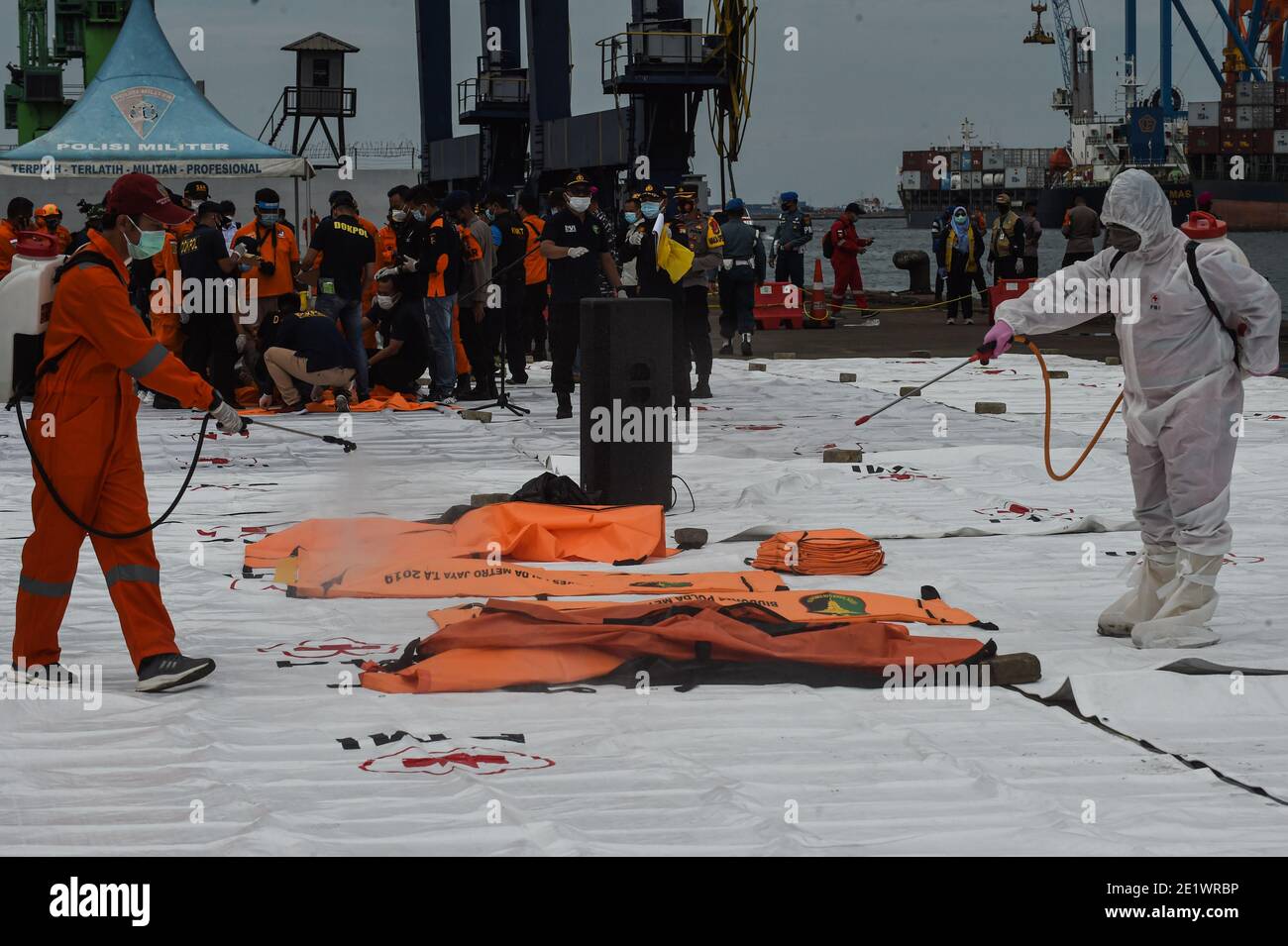 Jakarta, Indonesia. 10th Jan, 2021. Health workers spray disinfectant to bags of body parts of passengers on board the Sriwijaya Air flight SJ-182 at Tanjung Priok Port, Jakarta, Indonesia, Jan. 10, 2021. Rescuers on Sunday collected five bags of human body parts and three bags of debris of the Sriwijaya Air plane that crashed in the waters off the coast of Indonesian capital Jakarta, a senior official said. Credit: Agung Kuncahya B./Xinhua/Alamy Live News Stock Photo