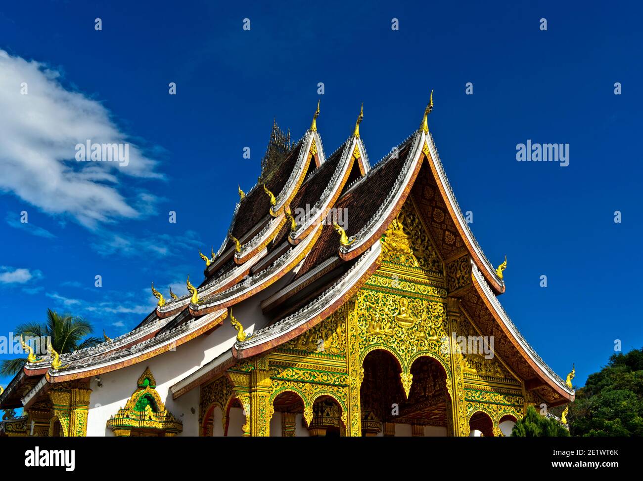 Multi-tiered roof in Thai style adorned with stylized Naga finials at the ends of the roof, Haw Pha Bang temple,  Luang Prabang, Laos Stock Photo