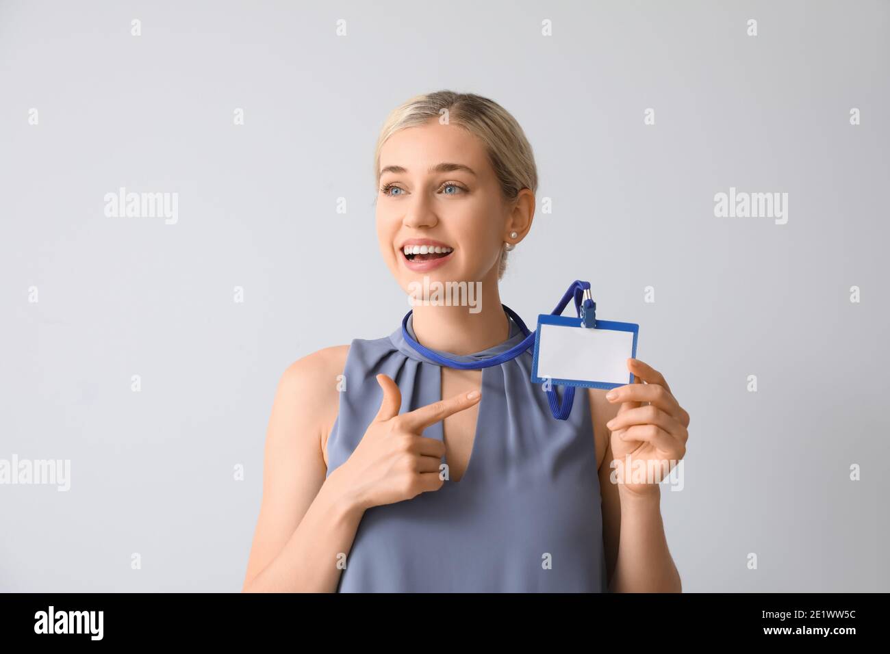 Young woman with blank badge on white background Stock Photo - Alamy