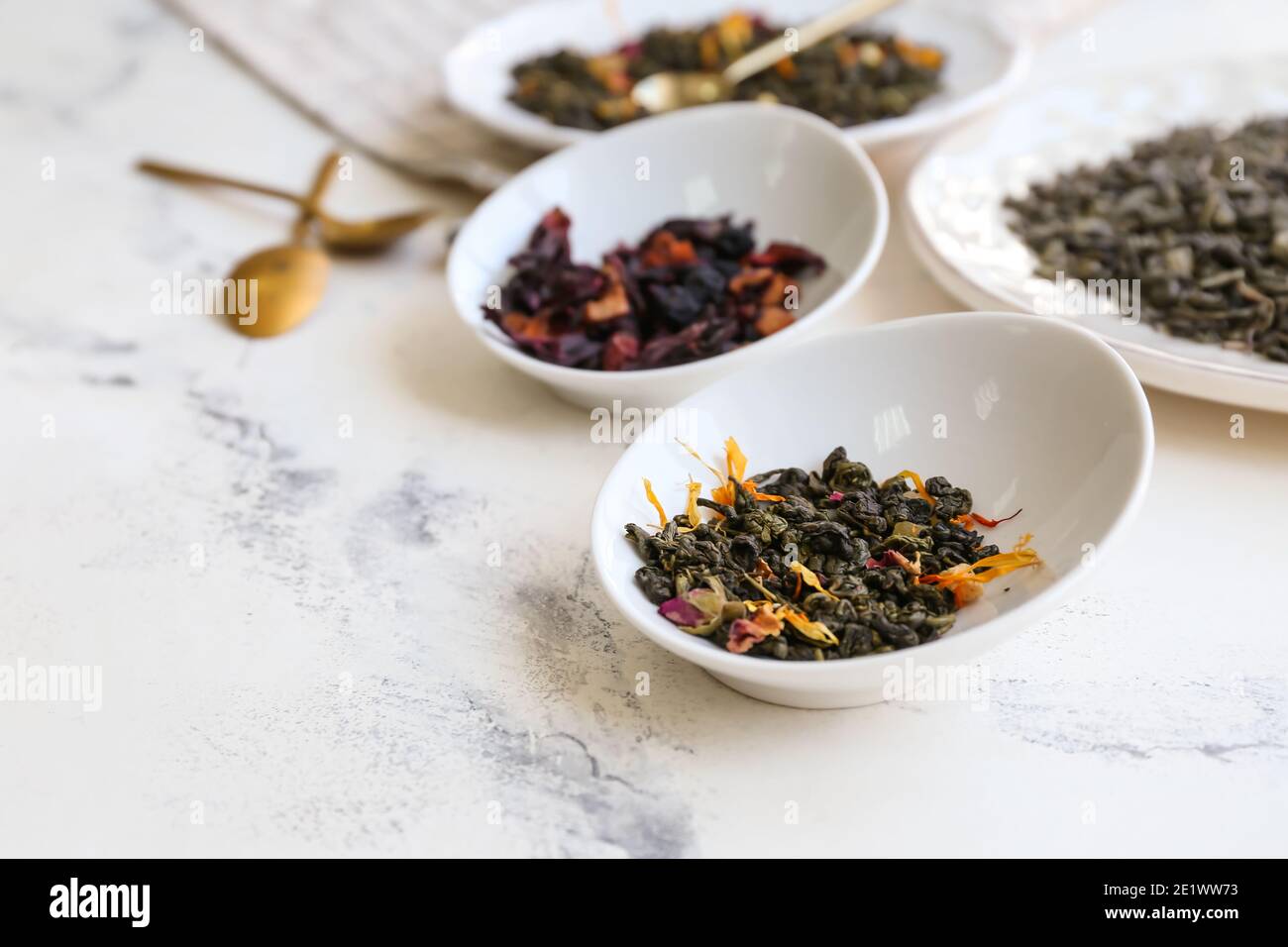 Composition with different green tea leaves in bowls on light ...