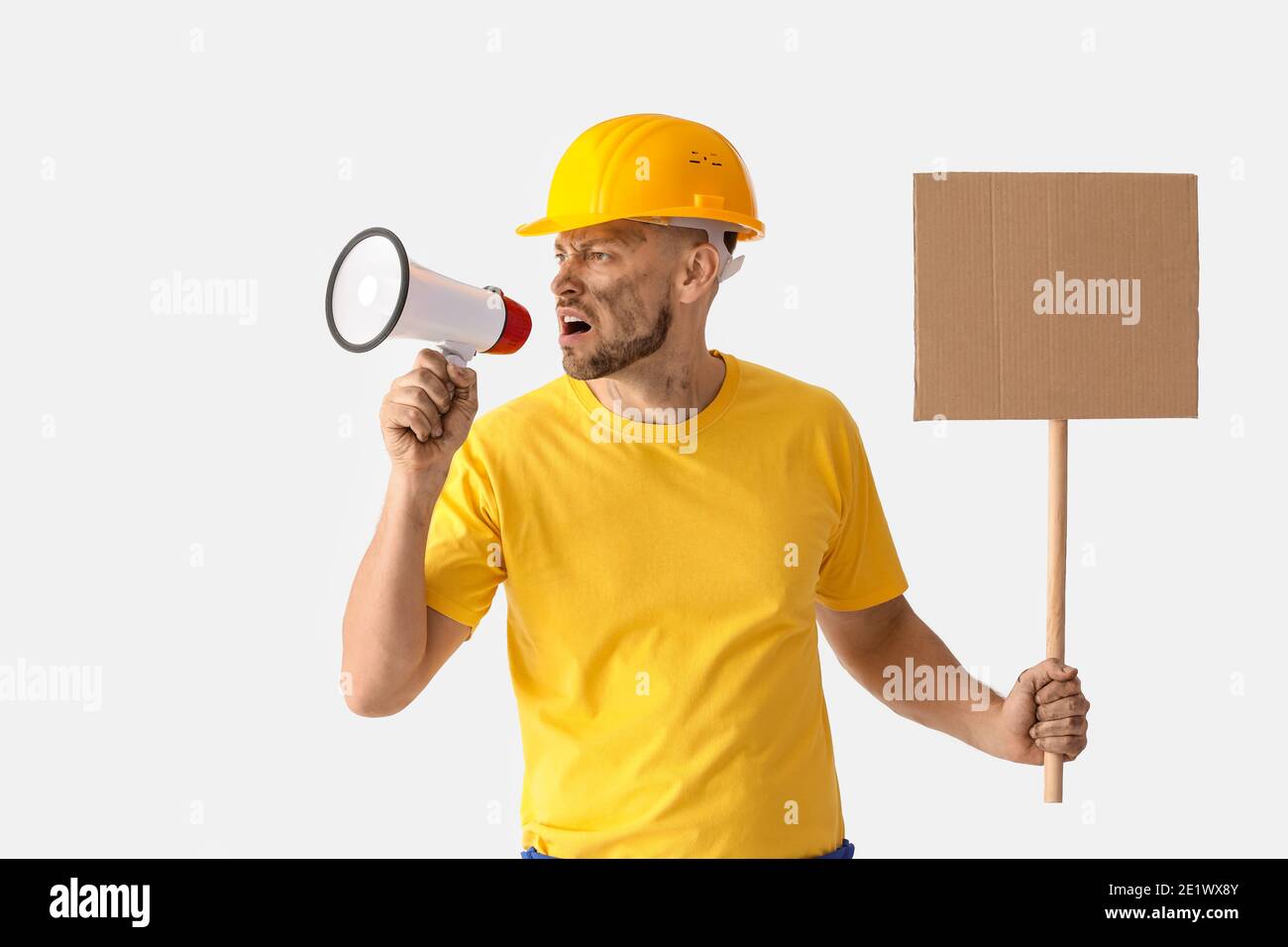 Protesting miner man with megaphone and placard on light background Stock Photo