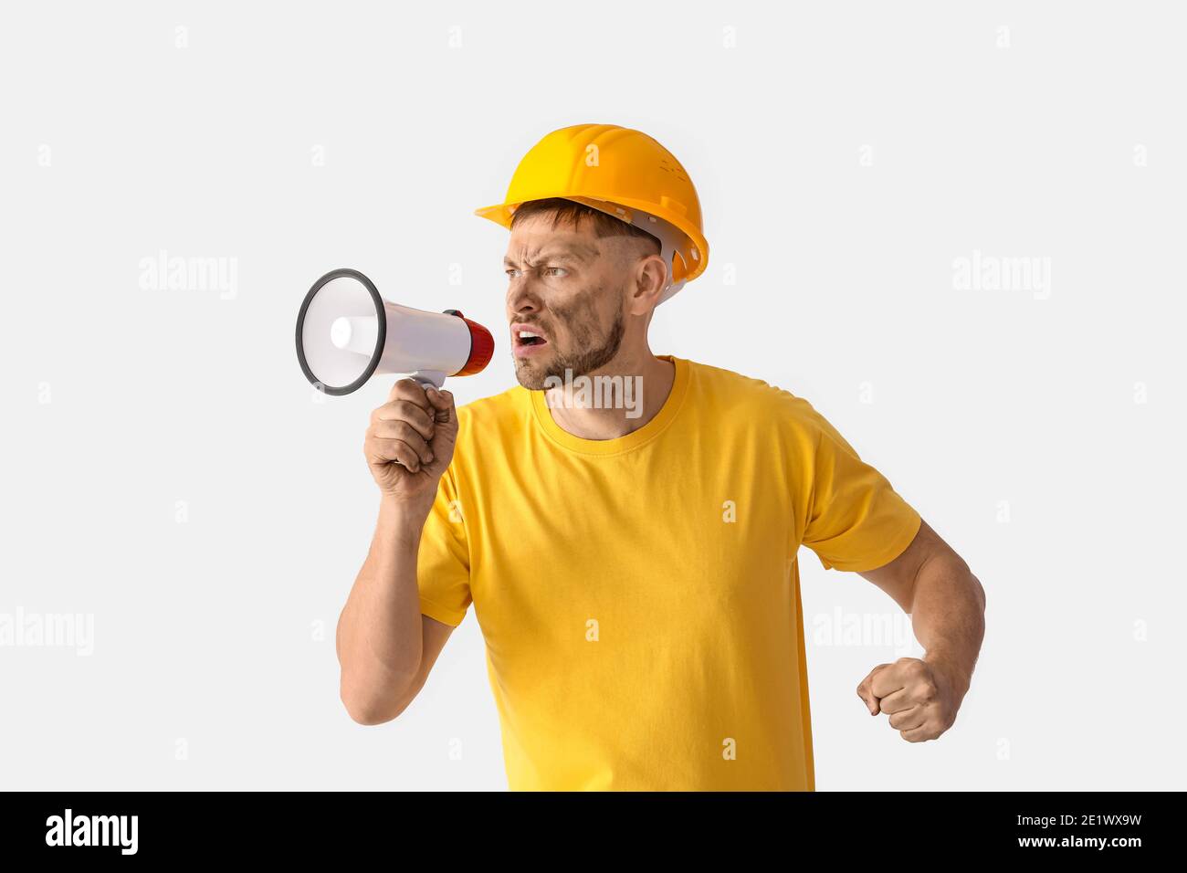 Protesting miner man with megaphone on light background Stock Photo