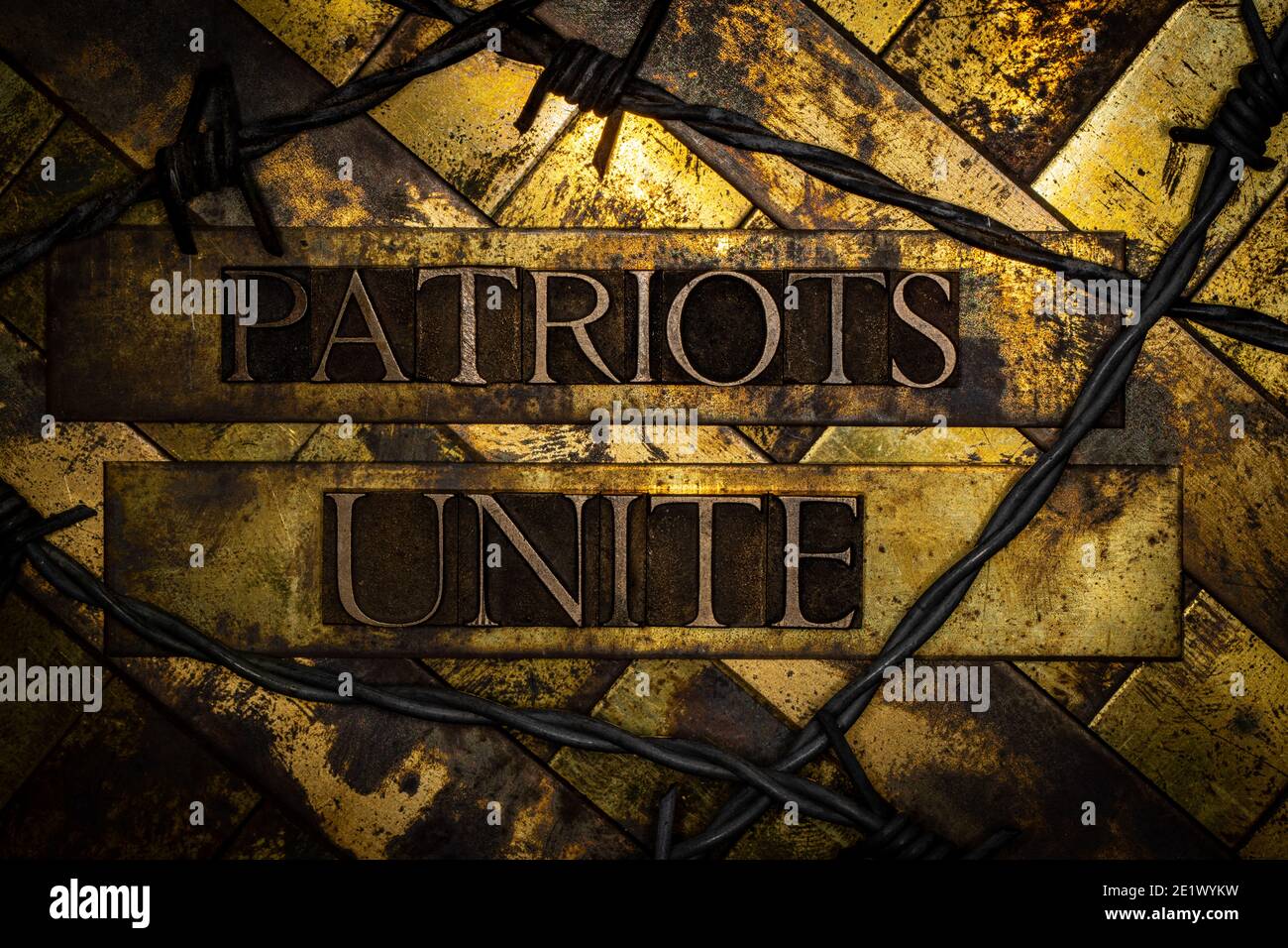 Patriots Unite text over copper 50 caliber bullet casings surrounded by barbed wire on grunge background Stock Photo
