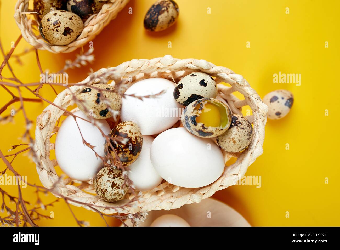 Easter eggs are minimalistically, decorated with dry flowers on yellow background. Top view, Copy space, Creative flat lay holiday composition. Stock Photo
