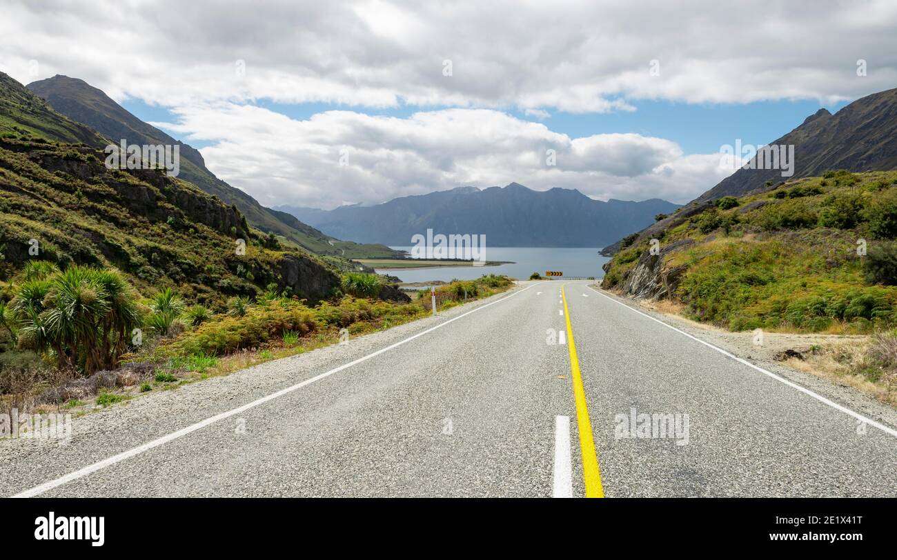 Road with views of mountains and Lake Hawea, The Neck, Otago, South Island, New Zealand Stock Photo