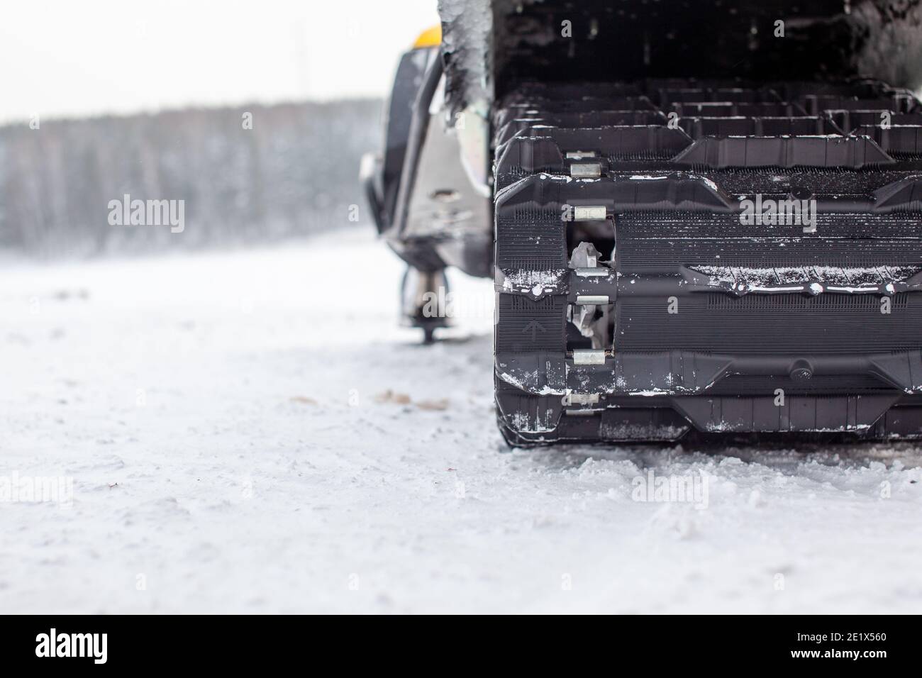 Snowmobile undercarriage in winter, closeup. Snowmobiling in the
