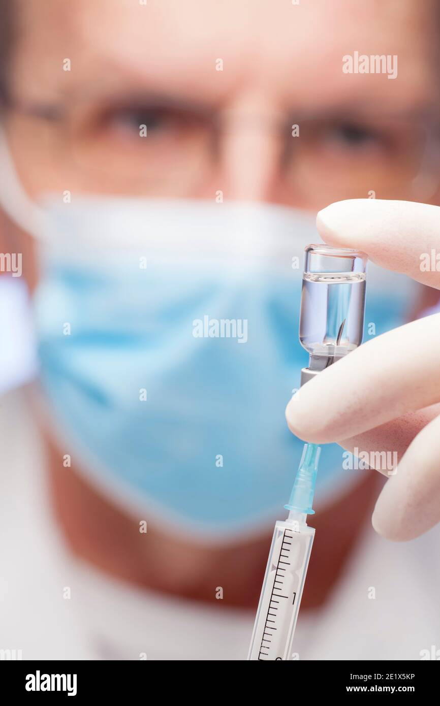 Close-up of doctor preparing a syringe for vaccination against covid-19 - focus on the syringe Stock Photo