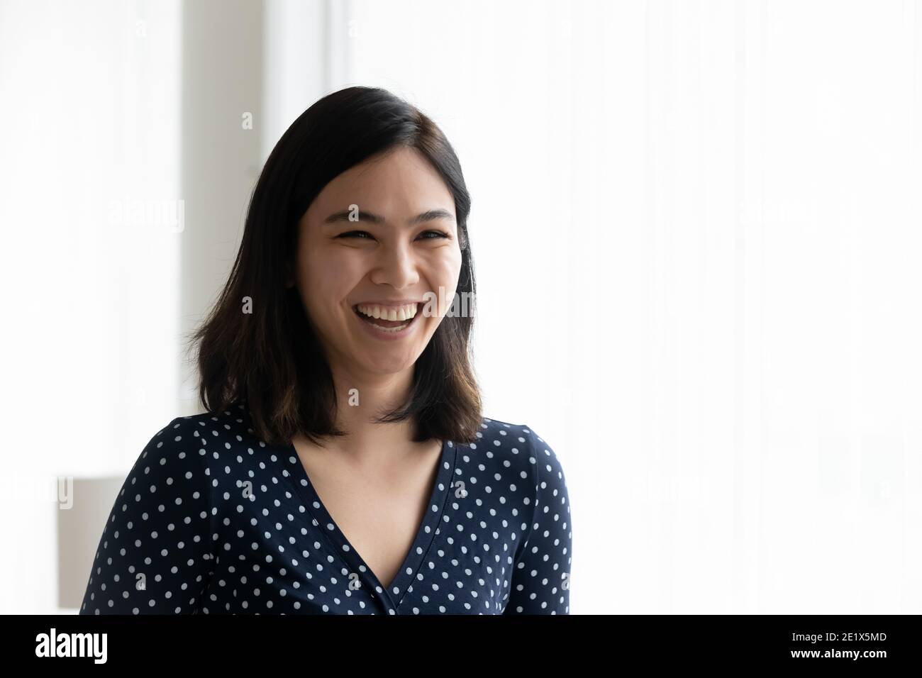 Happy emotional millennial mixed race korean asian woman laughing. Stock Photo