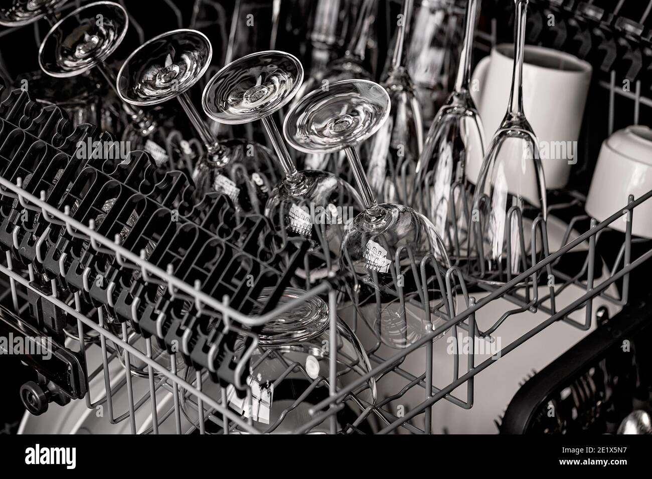 Clean dishes in the dishwasher. Wine glasses, sparkling wine glasses, white cups. Closeup