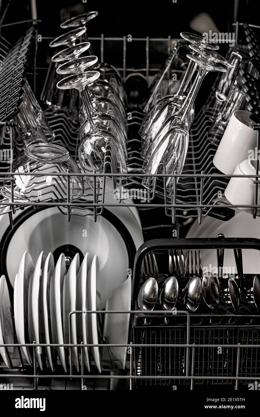 Clean dishes in the dishwasher. Wine glasses, glasses, cups, plates