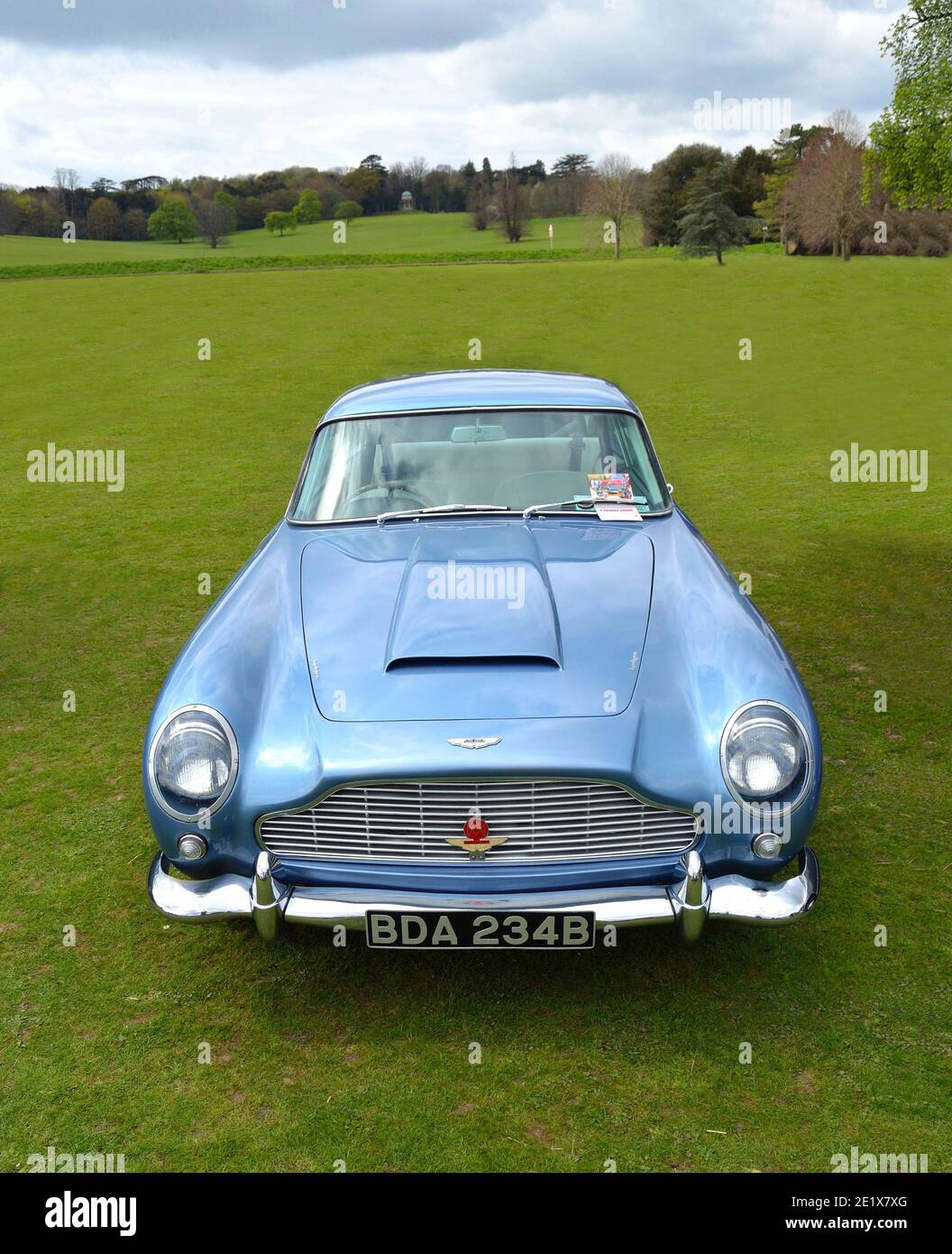 Classic Light Blue Aston Martin DB5 sports car parked on grass. Stock Photo