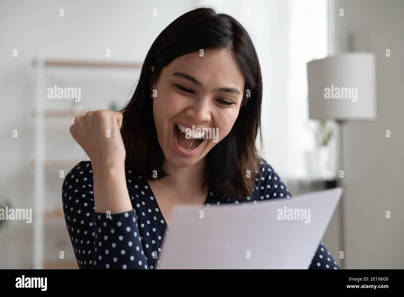 Emotional happy asian lady reading university admission notification. Stock Photo