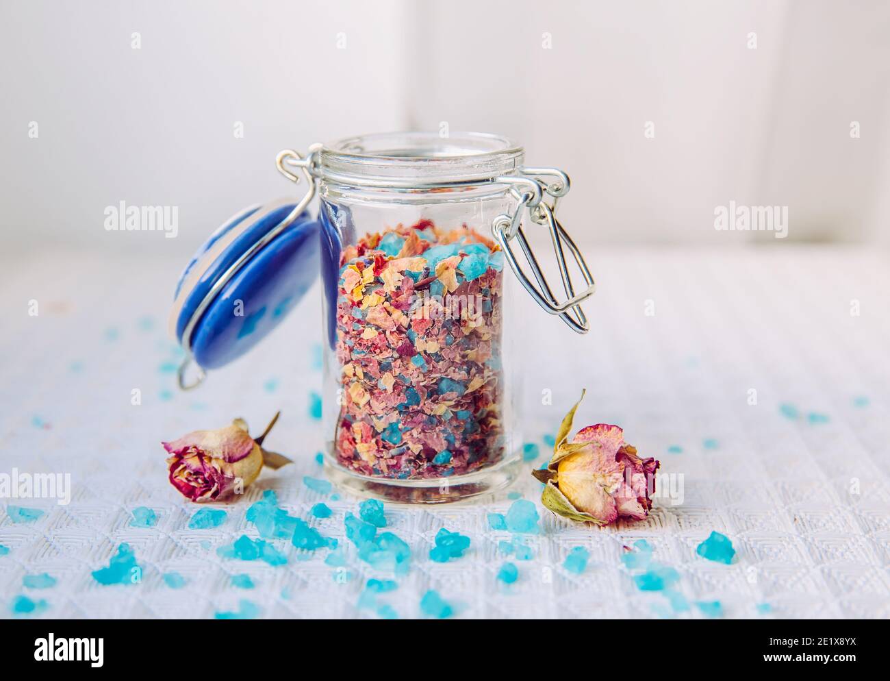 Homemade dry rose petals flower bath salt blend for aromatherapy and relaxation in bathtub, bath mix. Inside small cute jar. Bath salt mixed with herb Stock Photo