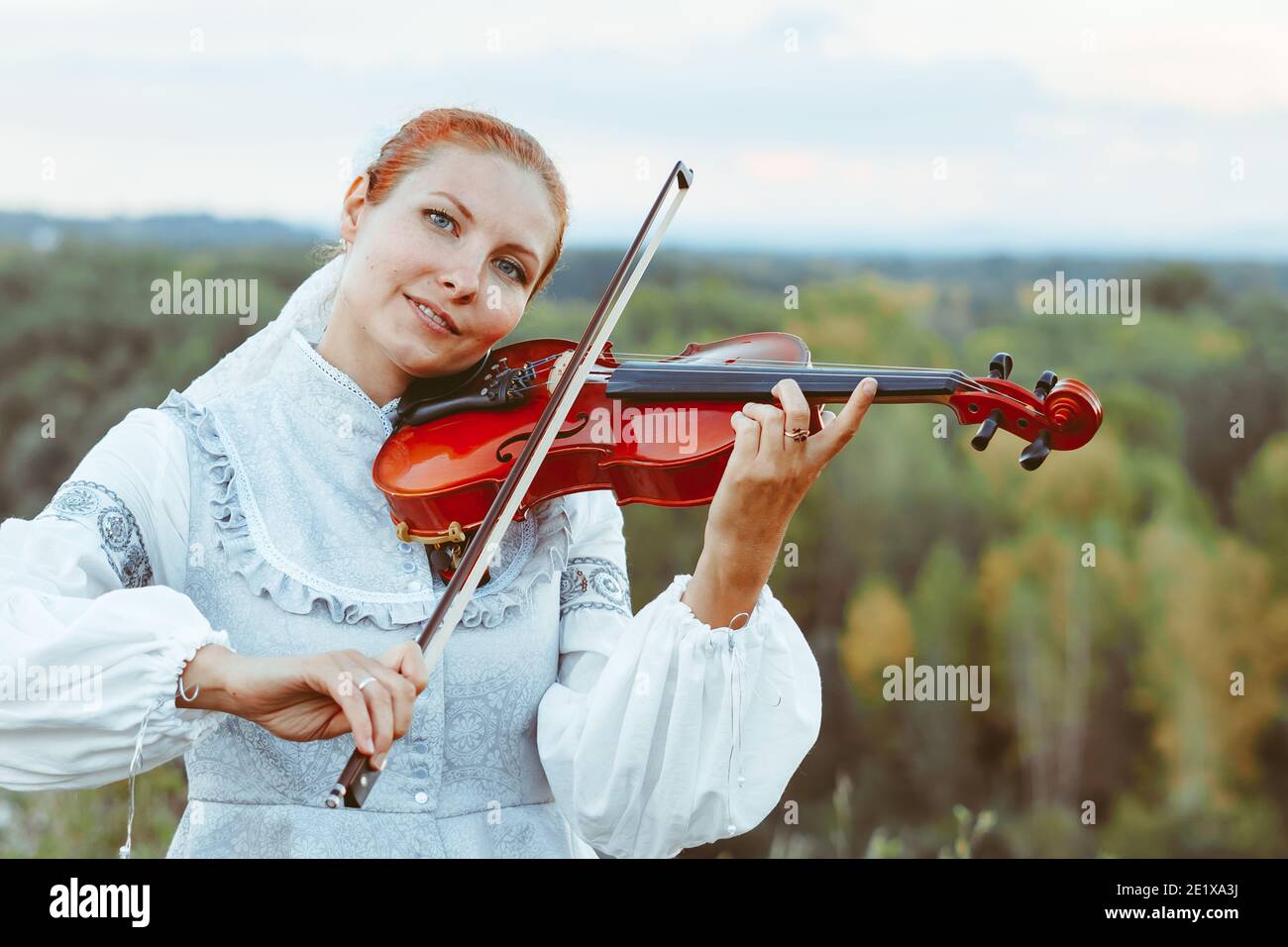 beautiful girl playing violin in white dress in forest Stock Photo - Alamy